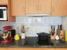 Load image into Gallery viewer, subway marble peel and stick tile in a kitchen behind induction cooktop, stuck over stainless steel splashback

