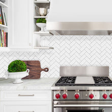 Load image into Gallery viewer, white and grey herringbone peel and stick tile kitchen splashback behind stovetop
